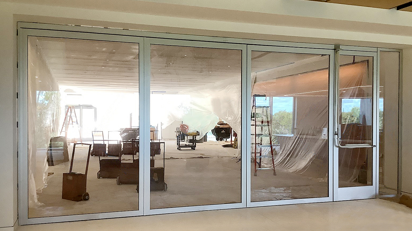 One three-panel center pivot door system with an integrated G2 outswing swing door and sidelite.