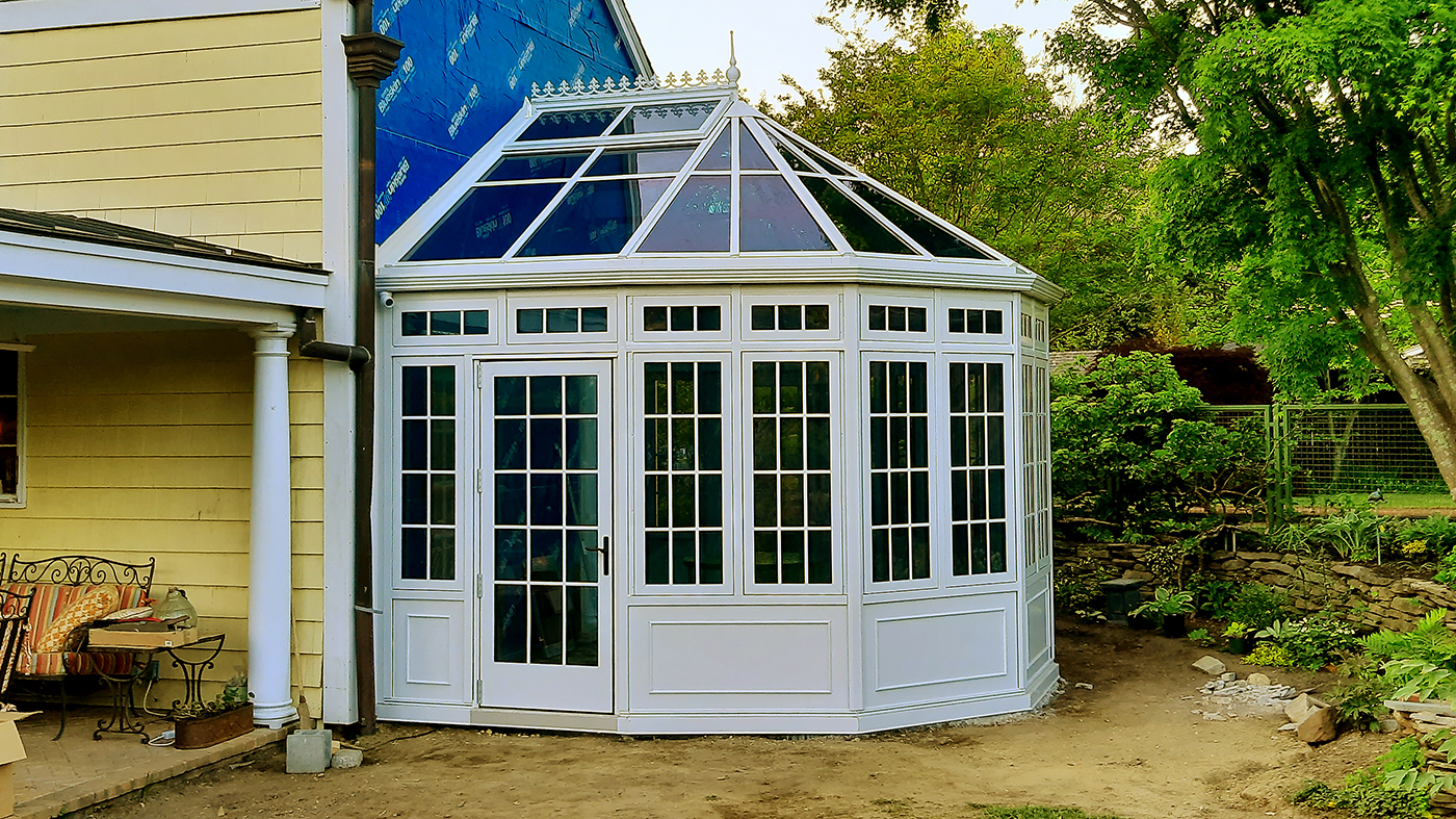 Straight eave double pitch bullnose end conservatory with a white exterior and custom blue interior.
