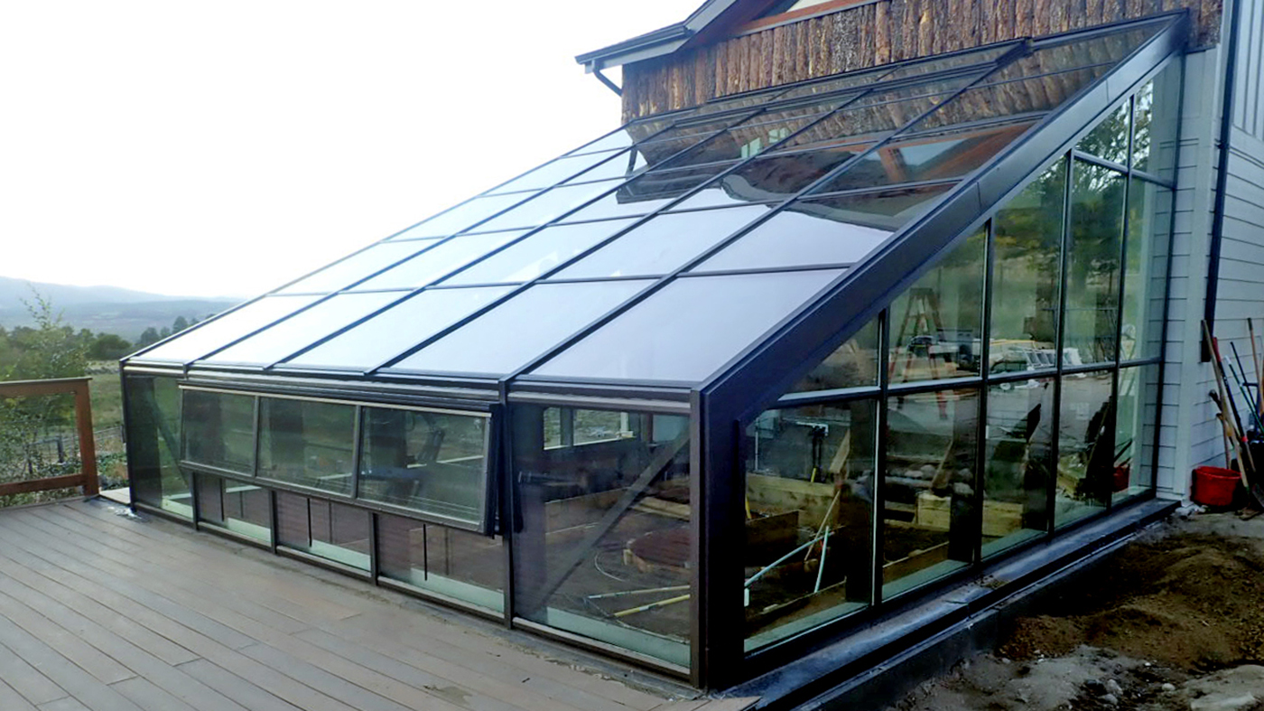 Straight eave lean-to greenhouse constructed with cross bracing on a sunken knee wall.