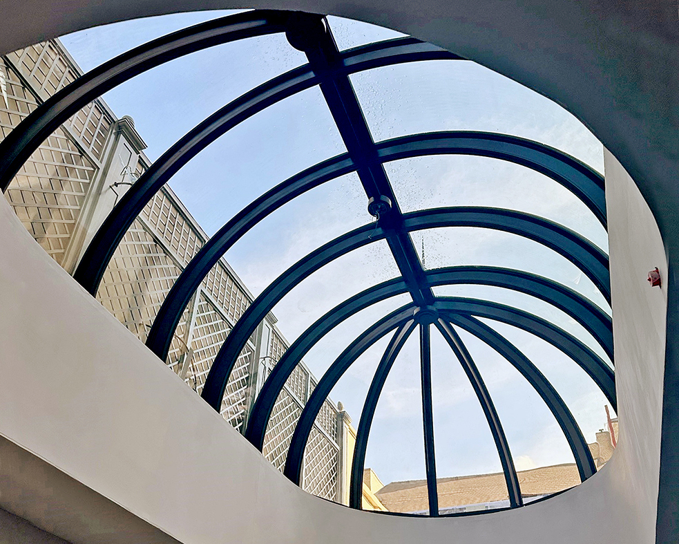 Curved eave double pitch segmented radius barrel vault skylight with true radius glass.