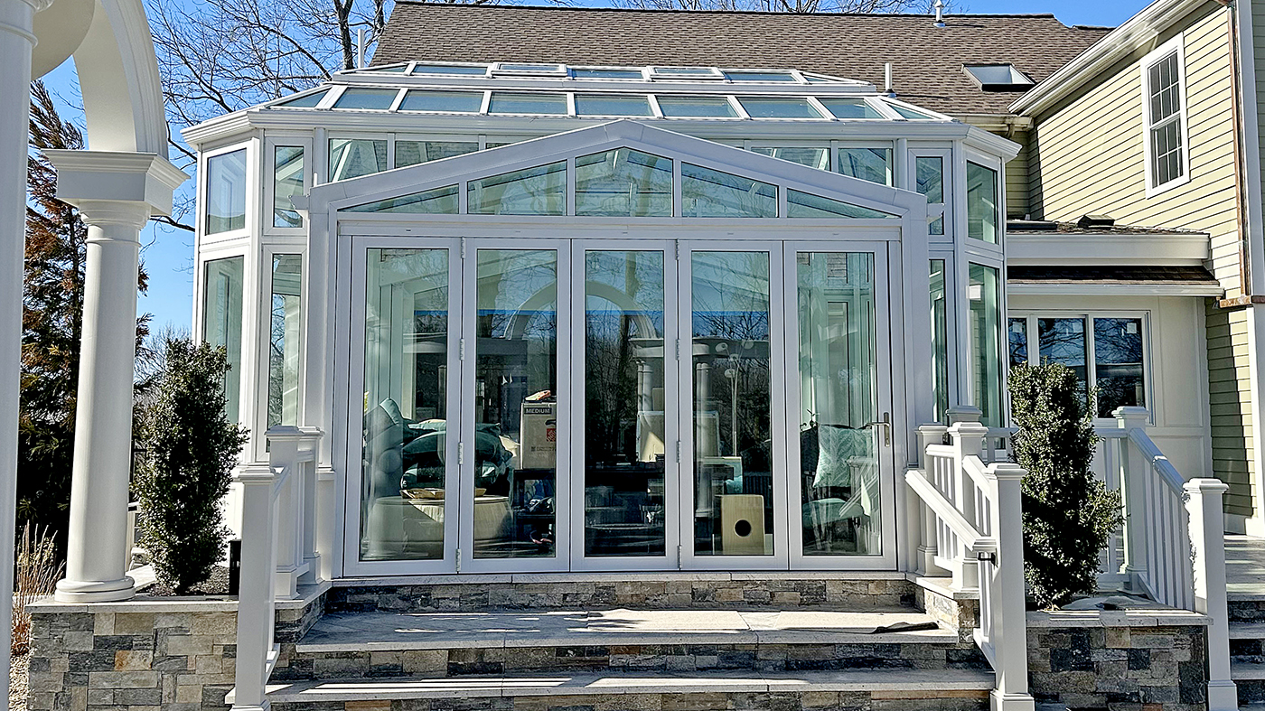One straight eave double pitch hip-end conservatory with an integrated five-panel G2 infold single door last panel (SDLP) bifold door unit, G2 outswing French door unit and a hip-end skylight with ridge vents.