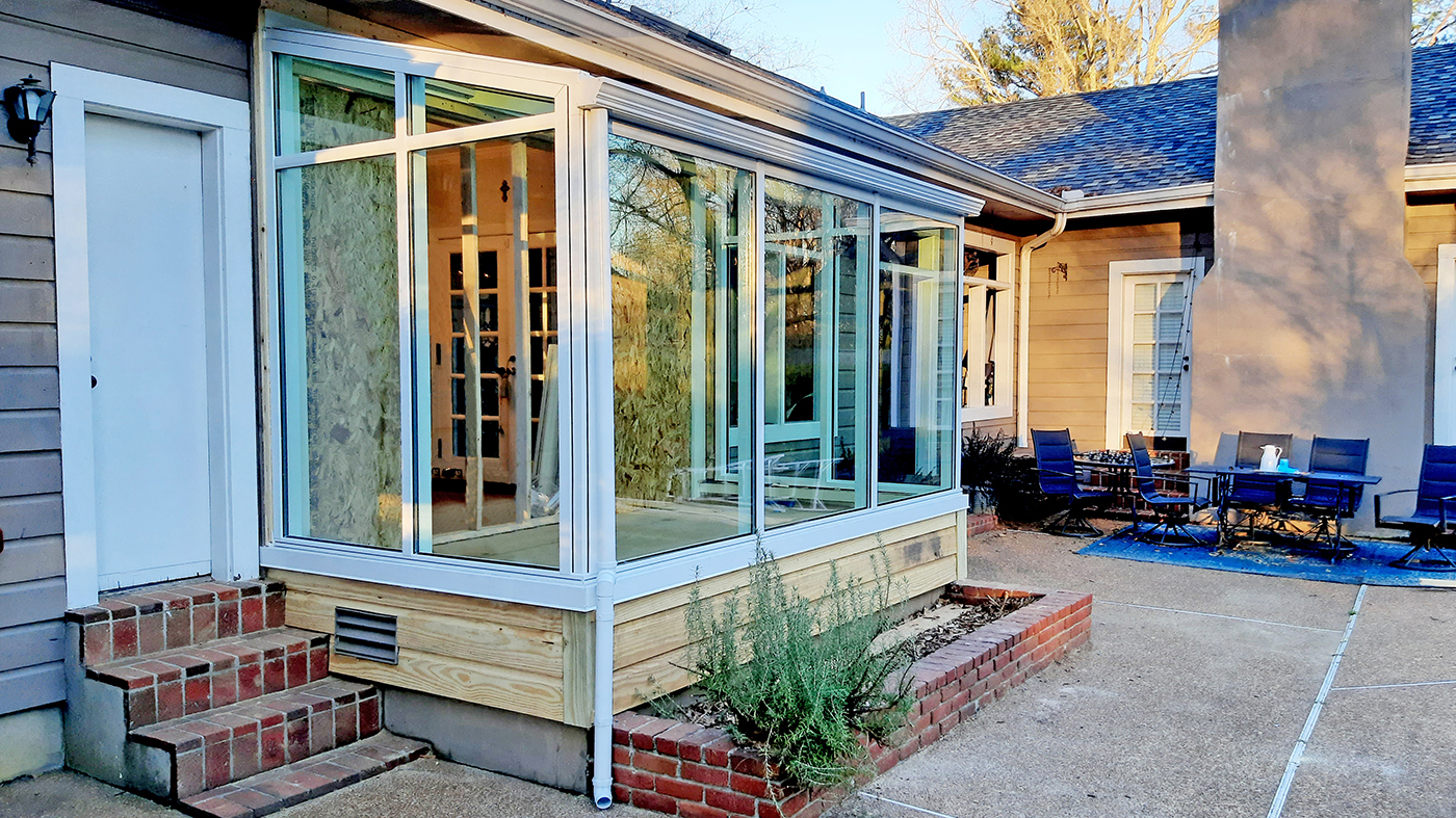 Straight eave lean-to sunroom with a detail photo of an aluminum downspout and pinoleum blinds