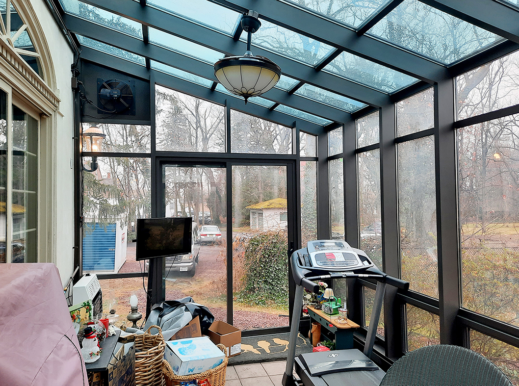 Straight eave lean-to sunroom with two sliding glass door units and nine awning window units