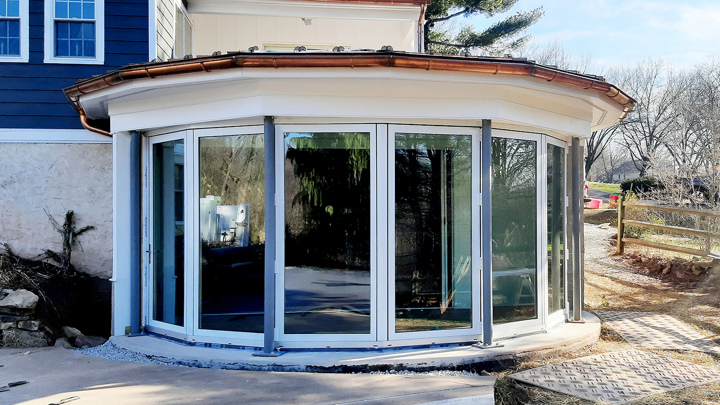 One seven-panel segmented radius bifold door unit with B-Series screens and a fixed window.