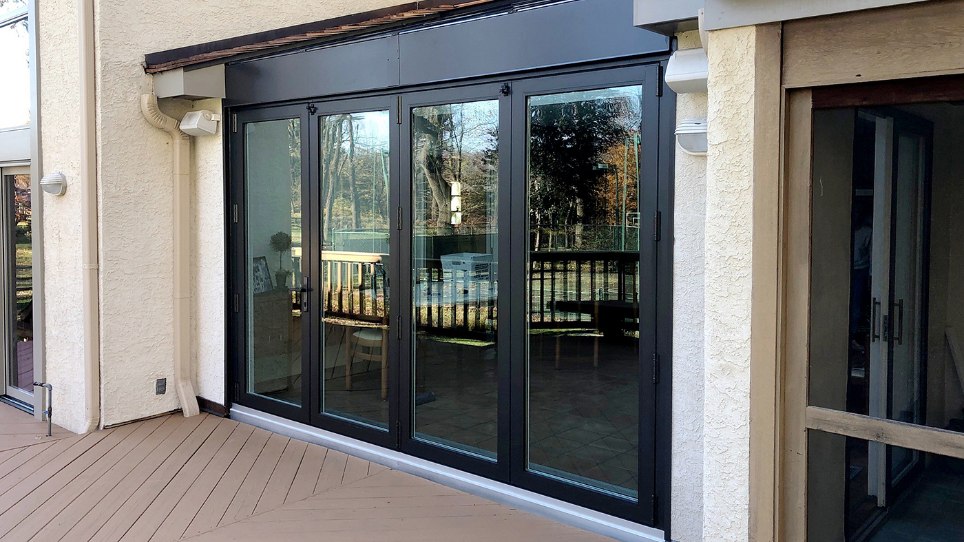 Straight eave lean-to sunroom with a dual-finish frame and a four-panel outfold single door hinged jamb (SDHJ) bifold door unit