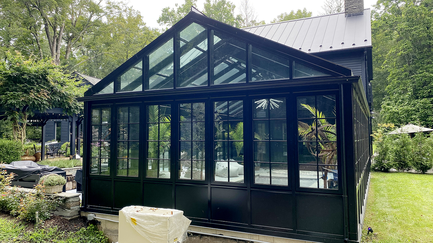 Straight eave double pitch conservatory with an integrated eight-panel G2 outfold split-wall bifold door unit and seven awning windows.