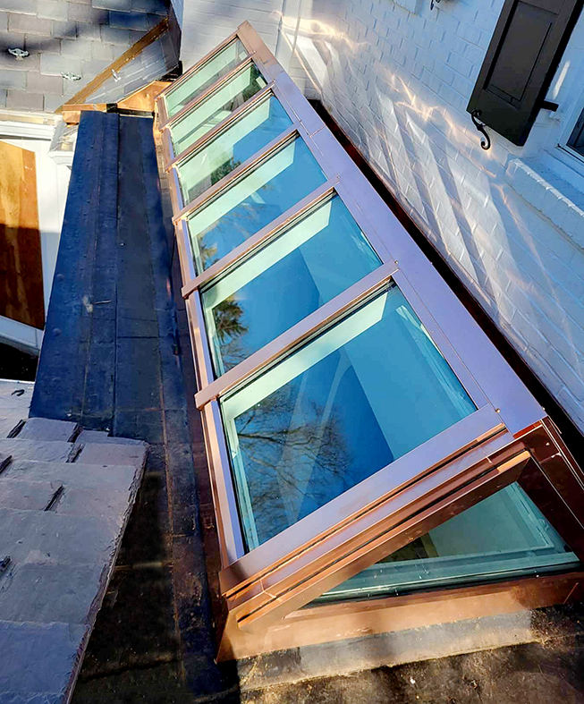 Straight eave double pitch copper-clad skylight.