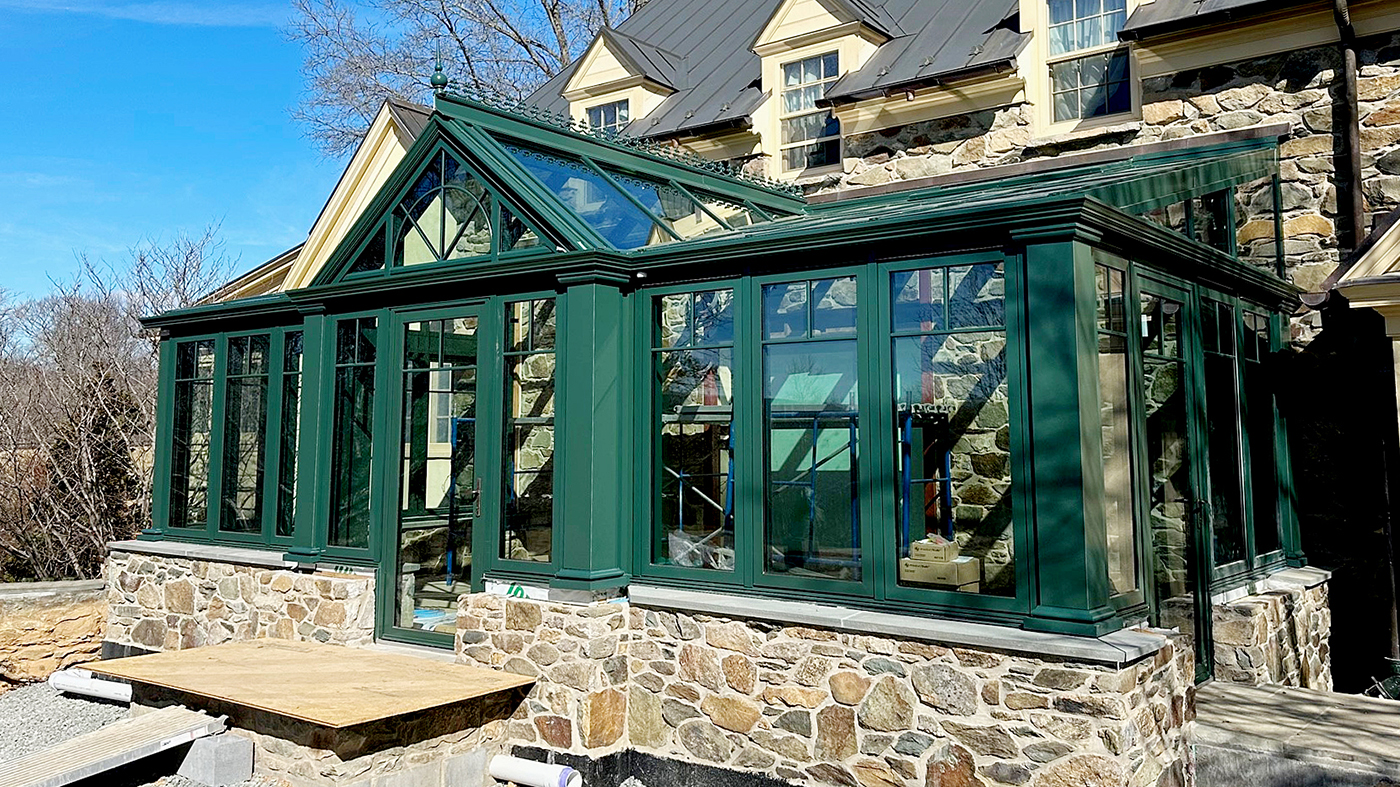 One straight eave lean-to conservatory with a dormer, two integrated inswing terrace doors, and four awning windows