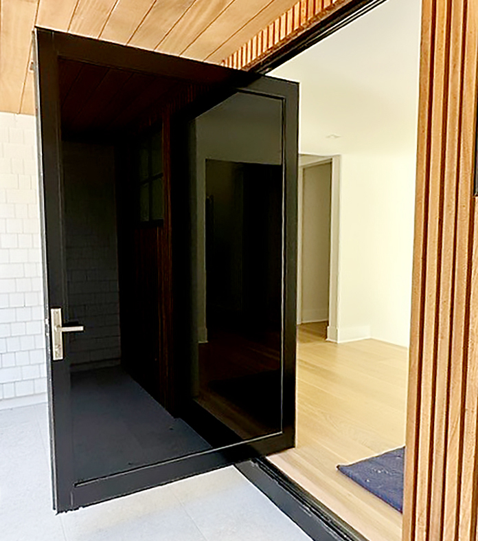 One G2 outswing pivot door with gray tempered black spandrel insulated glass makeup.