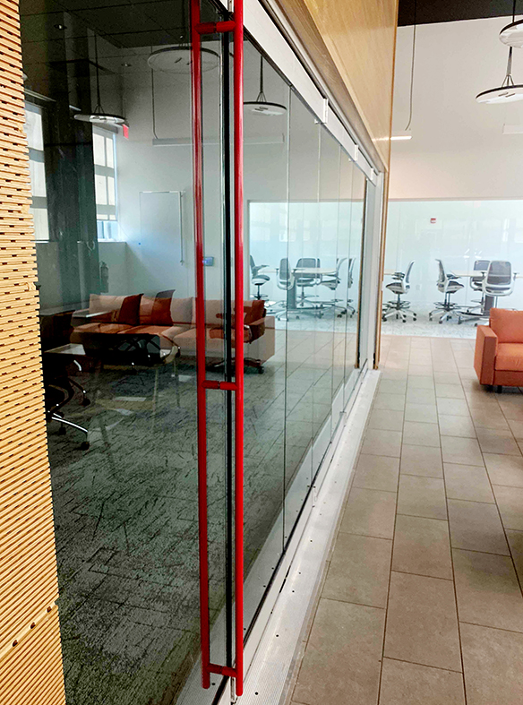 One eight-panel floating offset single door hinged jamb (SDHJ) pivot clear glass bifold door unit with red Bandwidth handles.