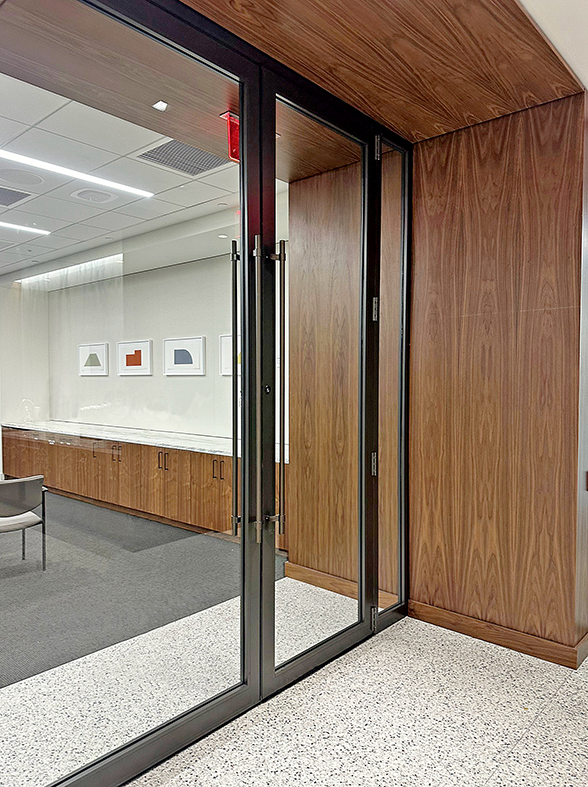 Two G2 three-panel center pivot doors flanked by two terrace doors with sidelites with Bandwidth pulls.