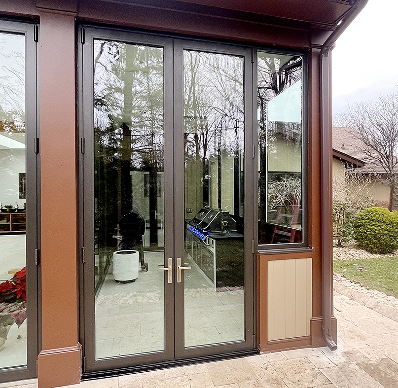 One four panel G2 outfold split-wall bifold window unit and one G2 outswing French door unit with a sidelite.