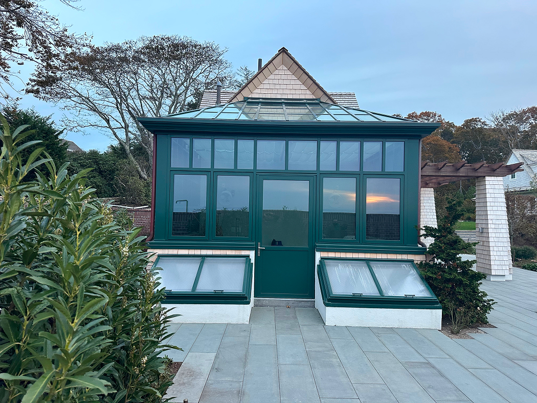 Straight-eave lean-to greenhouse with two hip ends, cold frames, 10 awning windows, and one terrace door.